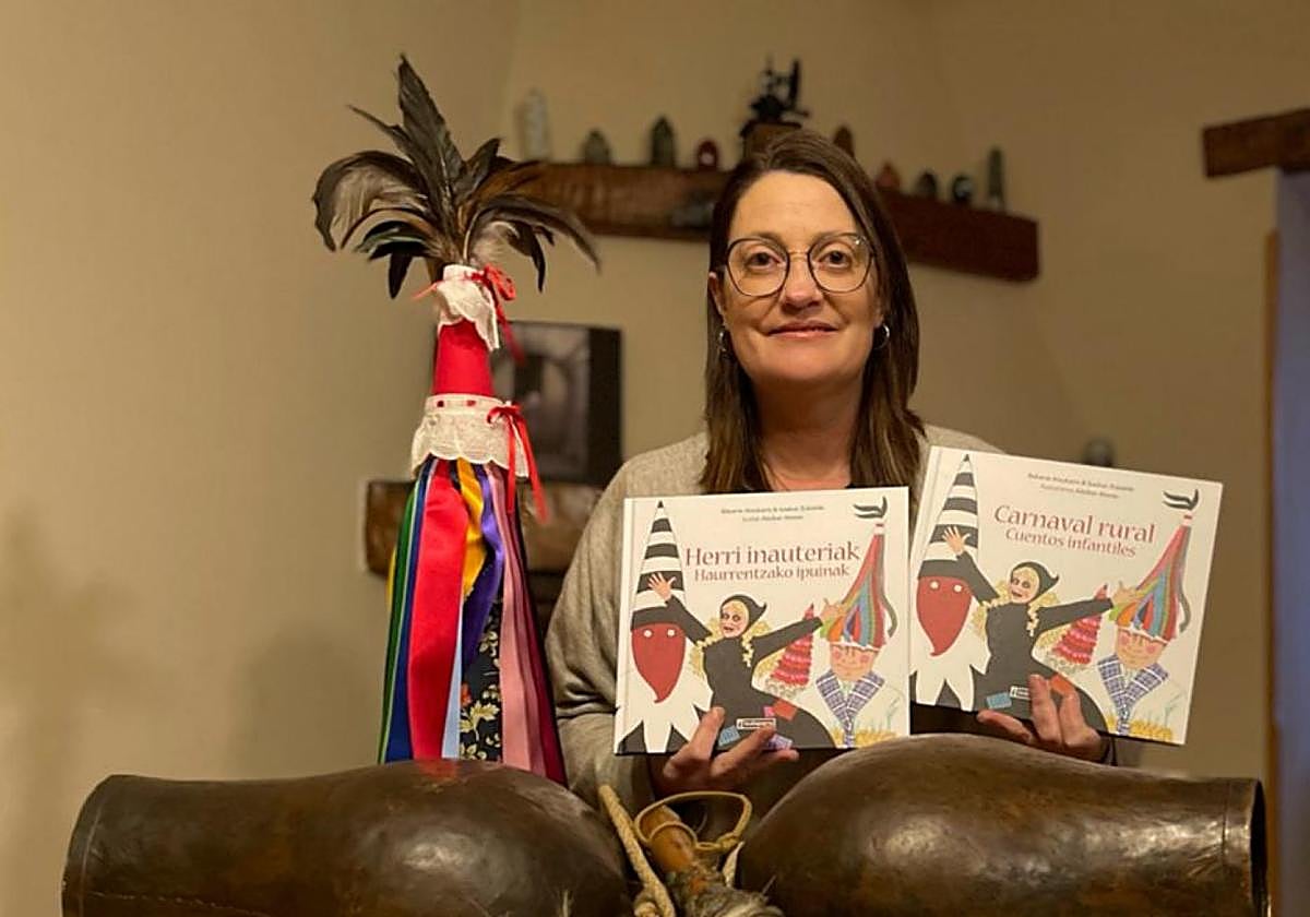 Izaskun Zubialde posa con dos ejemplares del libro y un atrezzo muy vinculado carnaval euskaldun.