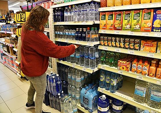 Una mujer mira las estantería de agua mineral, en un supermercado de Eibar.