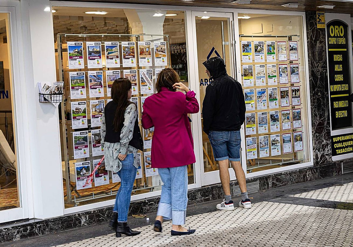 Un joven mira el escaparate de una inmobiliaria en el centro de San Sebastián.
