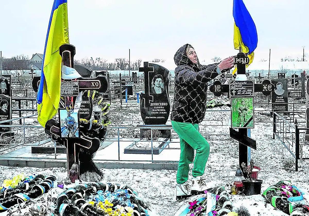 Una viuda visita la tumba de su marido en el cementerio de Lozuvatka.