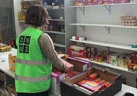 Una mujer prepara alimentos para repartir entre los más necesitados.