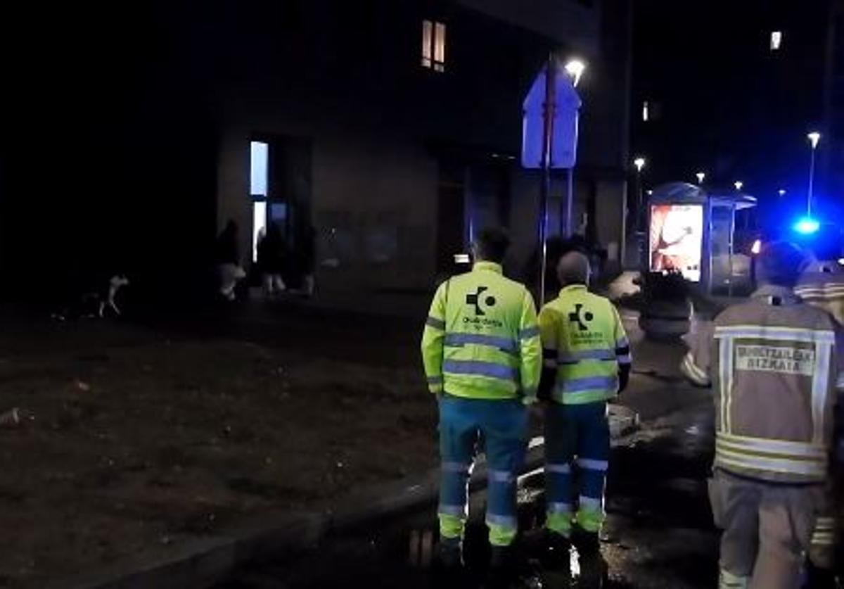 Personal sanitario y bomberos ante el edificio incendiado.