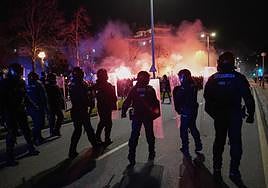 Agentes de la Ertzaintza intervienen durante los altercados previos al partido entre la Real y el PSG.
