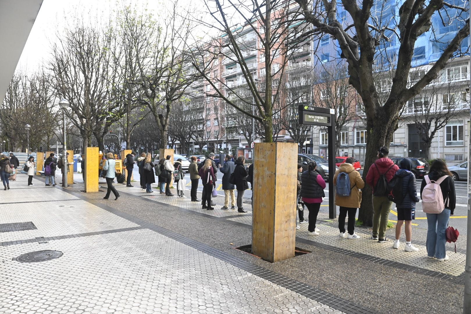 Usuarios de Dbus aguardan al autobús en una parada del barrio de Amara