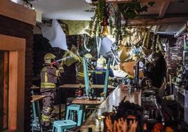 Los bomberos de Vitoria inspeccionan el interior del local donde se ha producido el derrumbe.