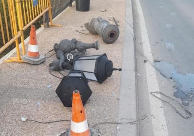 Restos de las farolas contra las que chocó y que derribaron también la valla