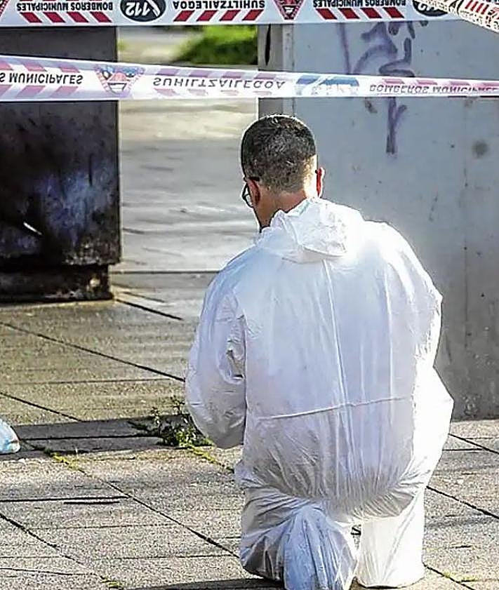 Imagen secundaria 2 - Un agente uniformado acompaña a una familiar del pequeño de 11 meses, mientras que otro graba desde la ventana donde ocurrieron los hechos. Un policía fotografía el lugar del impacto junto al pañal del bebé. 