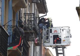 El equipo de Bomberos desde una escala rescata por el balcón a un vecino del edificio afectado por el fuego.