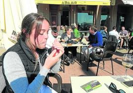 Una joven se enciende un cigarrillo en la terraza de un bar de Donostia.