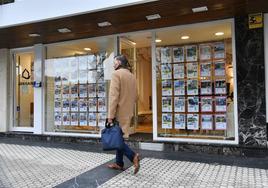 Un hombre camoina junto a una inmobiliaria en el centro de San Sebastián