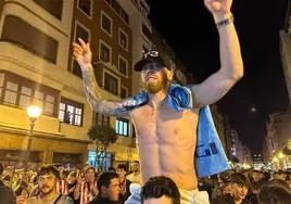 Muniain, a hombros de un aficionado, durante la espontánea celebración anoche en Bilbao.