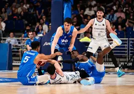 Barcello en el suelo rodeado por jugadores del Estudiantes.