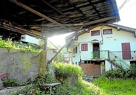 Dos agentes de la Ertzaintza pasan junto al portal donde se cometió el crimen, en un tercer piso.