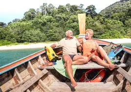 Una pareja de jubilados toma el sol en una embarcación.