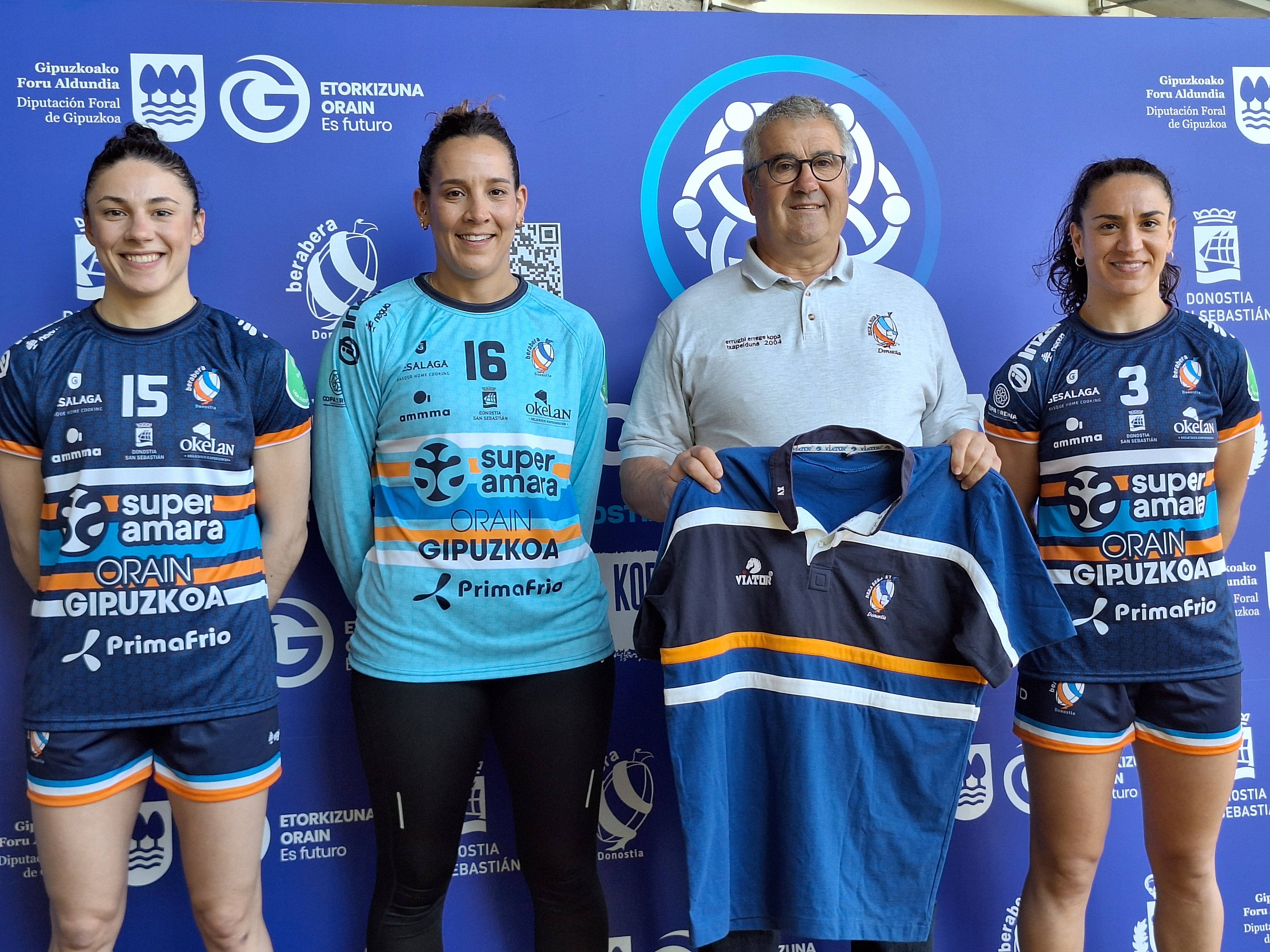 Maitane Etxeberria, Maddi Aala y Esther Arrojeria, con las nuevas camisetas, flanquean al presidente del Bera Bera, Fernando Díez, que sujeta la de los campeones de rugby de hace veinte años,