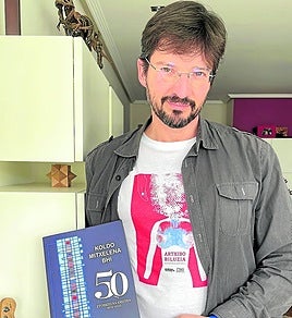 Oscar Picazo sostiene el libro del 50 aniversario de Koldo Mitxelena