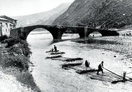 Un par de almadieros traslada troncos por el río Ezka, en una antigua imagen al paso por Burgi.