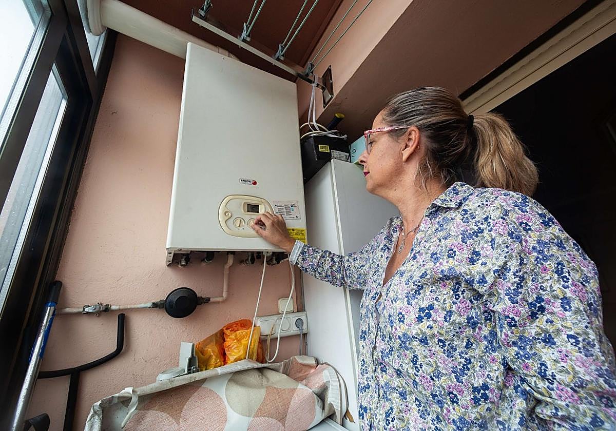Una mujer regula la caldera en su casa de Irun.