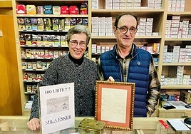 Ixiar Unamuno y Miel Anduaga en el mostrador con los cuadros conmemorativos y artículos antiguos.