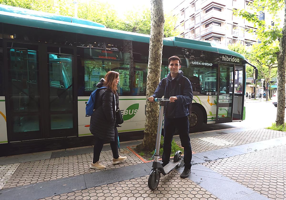 Álvaro Mendo, con su patinete eléctrico junto a un vehículo de Lurraldebus.