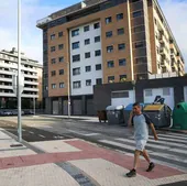 Un hombre pasea junto a un edificio de VPO en Astigarraga.