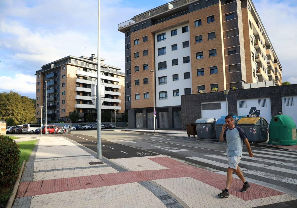 Un hombre pasea junto a un edificio de VPO en Astigarraga.