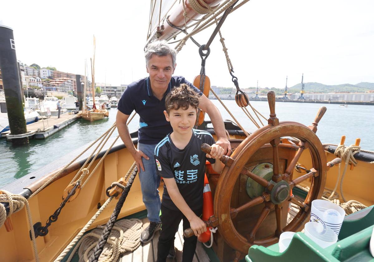 Martín Rodríguez sujetando el timón de 'La Recouvrance' junto a su padre.