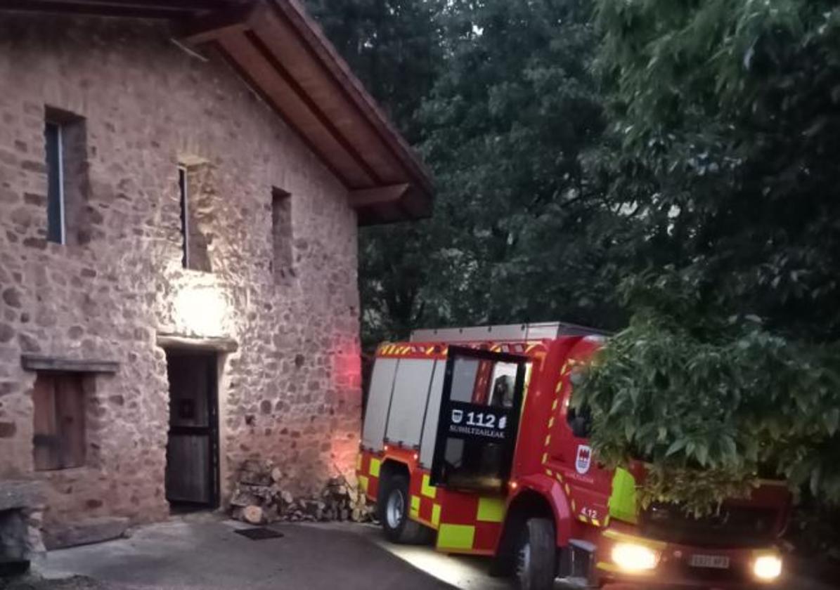 Un camión de los bomberos en la entrada del caserío en el que se ha declarado el incendio.