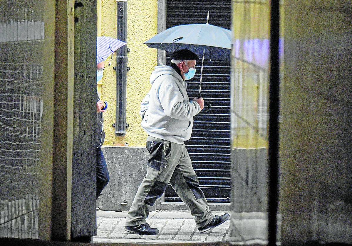 Un hombre camina por la calle con una mascarilla.