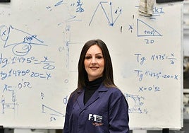 Susana posa delante de una pizarra con las fórmulas matemáticas que aplica después en el aula.