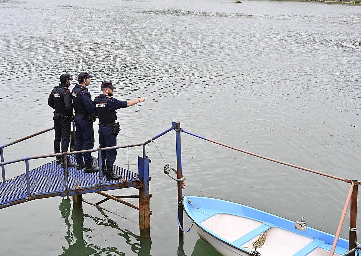 Imagen secundaria 1 - Imagen del rescate y tres tres agentes ante el lugar donde cayó el joven