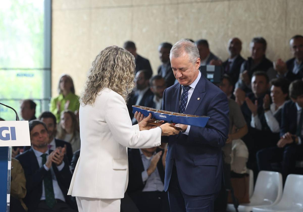 Isabel Busto entrega una escultura de una trainera a Iñigo Urkullu en el acto de este jueves.