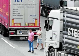 Dos transportistas atascados esperan en la calzada.