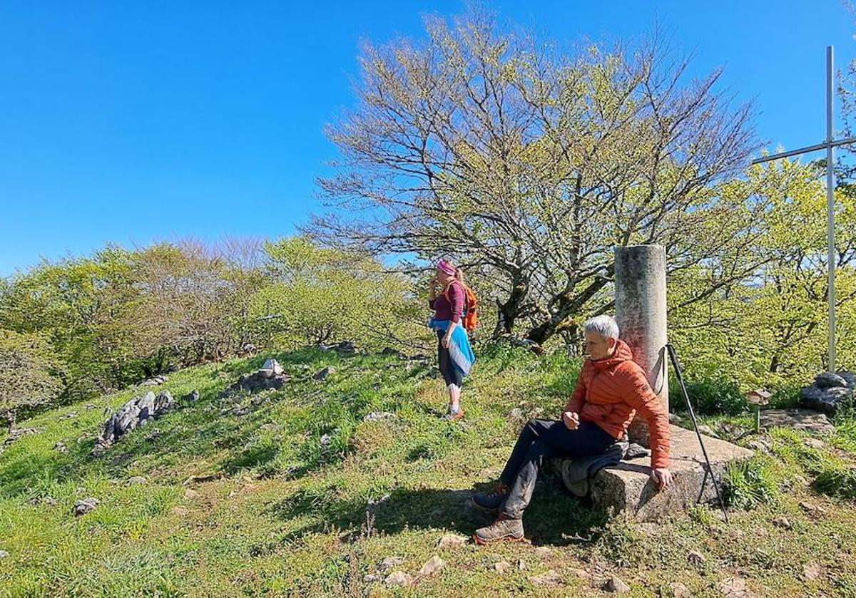 El donostiarra Javier y Mila posan junto al buzón geodésico de Otsabio.