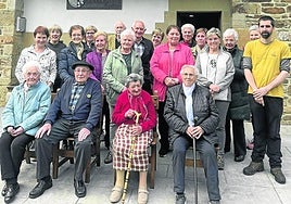 Olabartarras que han participado en el libro, y su autor Ander Lizarralde, delante de la sociedad del barrio rural.