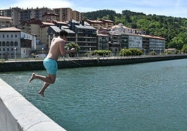 Chapuzón. Un joven se lanza al agua en Deba para refrescarse del calor.