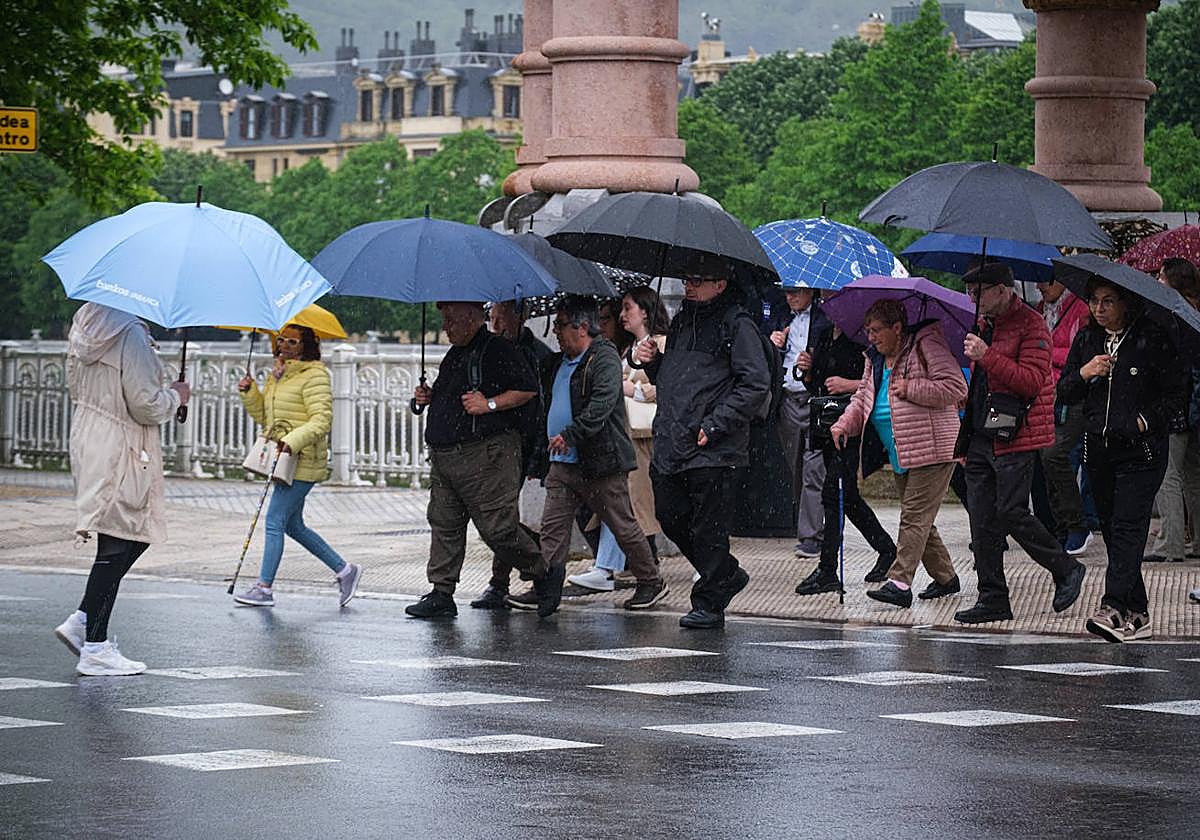 Ciudadanos pasean en una jornada lluviosa en Donostia.