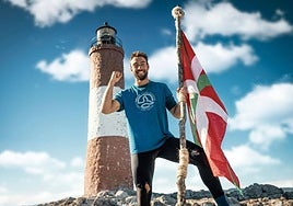 Jokin, con la ikurriña de El Conquis en el faro del fin del mundo.