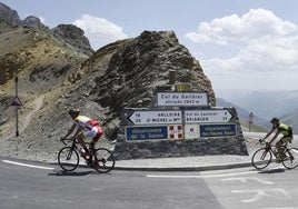 Dos cicloturistas coronan el Galibier en el sentido en el que lo cruzará la etapa de este martes, hacia la meta de Valloire.