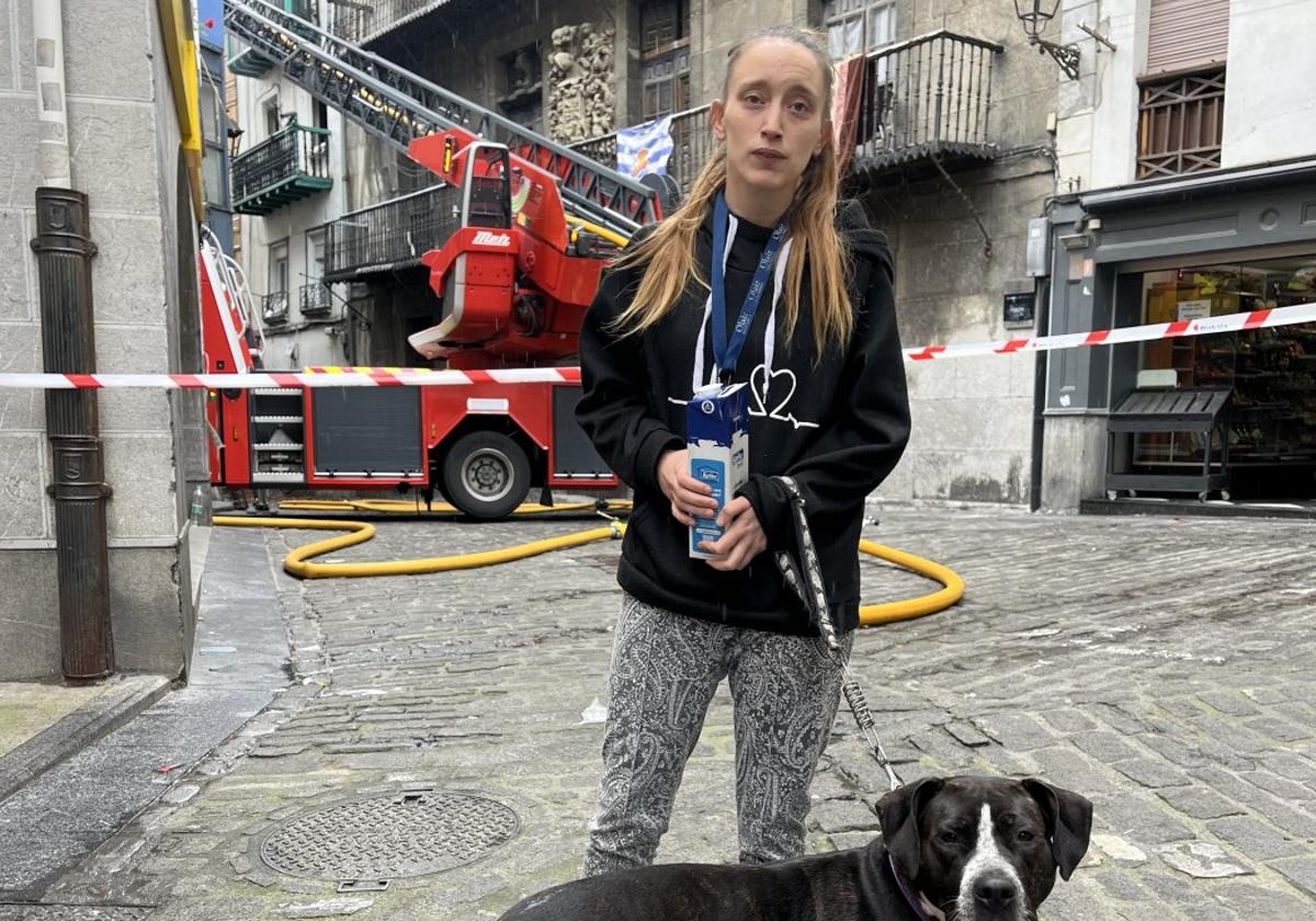 Lara Yuste, junto a su perra 'Txula', frente al edificio incendiado.