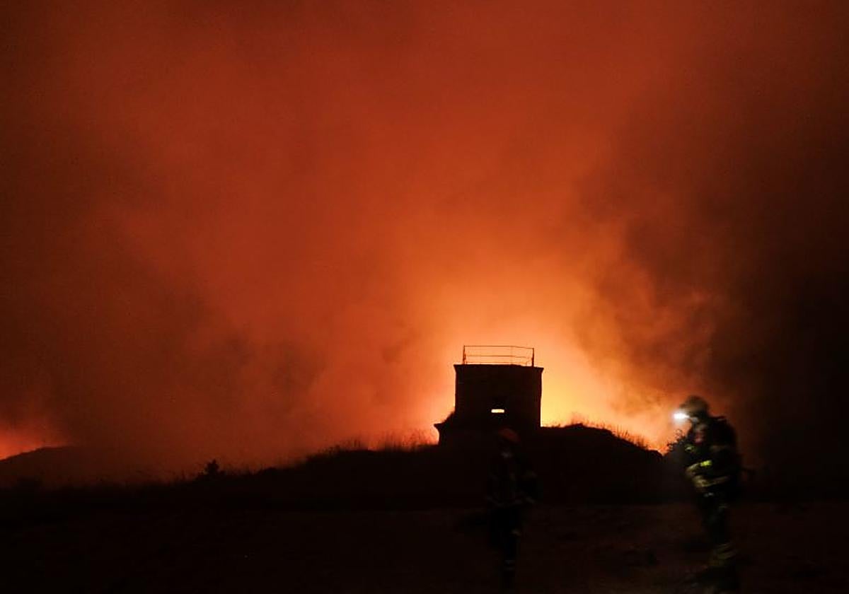 Un bombero vigila las llamas que se extienden en el interior del fuerte de San Cristóbal a las tres de la madrugada
