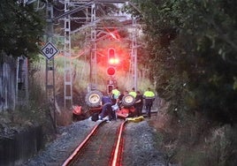 Efectivos de la Ertzaintza así como técnicos de ETS trabajan en la retirada del tractor accidentado de las vías del tren en Usurbil.