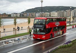 Un autobús turístico de Donosti City Tour junto a la playa de la Concha.
