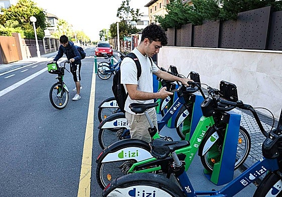 Dos jóvenes cogen bicicletas eléctricas en la estación de Dbizi en Ondarreta.