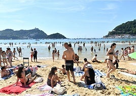 Cientos de personas disfrutan de un día soleado en la playa de La Concha de San Sebastián.