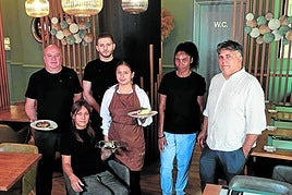 El equipo al completo de La Vinoteca, con algunos de los ricos platos que preparan.