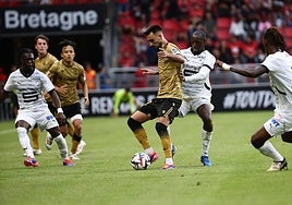 Brais aparece rodeado por tres jugadores del Rennes en un reflejo de lo que fue el partido en el Roazhon Park.