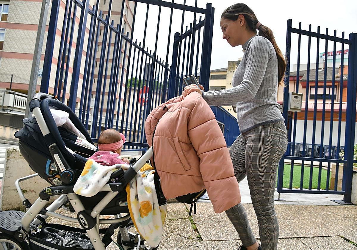 Una mujer camina con su bebé por Eibar.