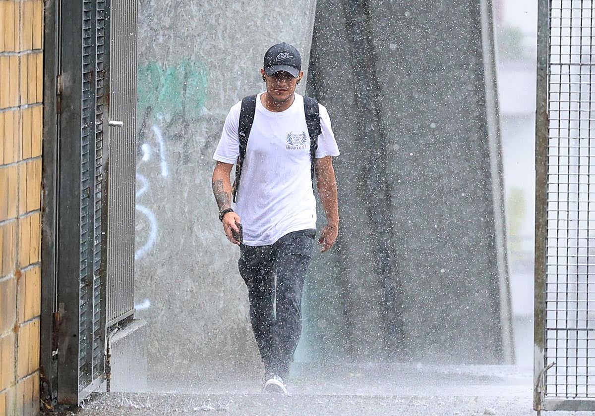 El chaparrón ha pillado desprevenido a este joven en Irun.