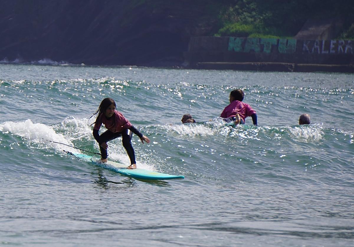 Una joven practica surf en la playa de Deba, dentro del curso de verano.